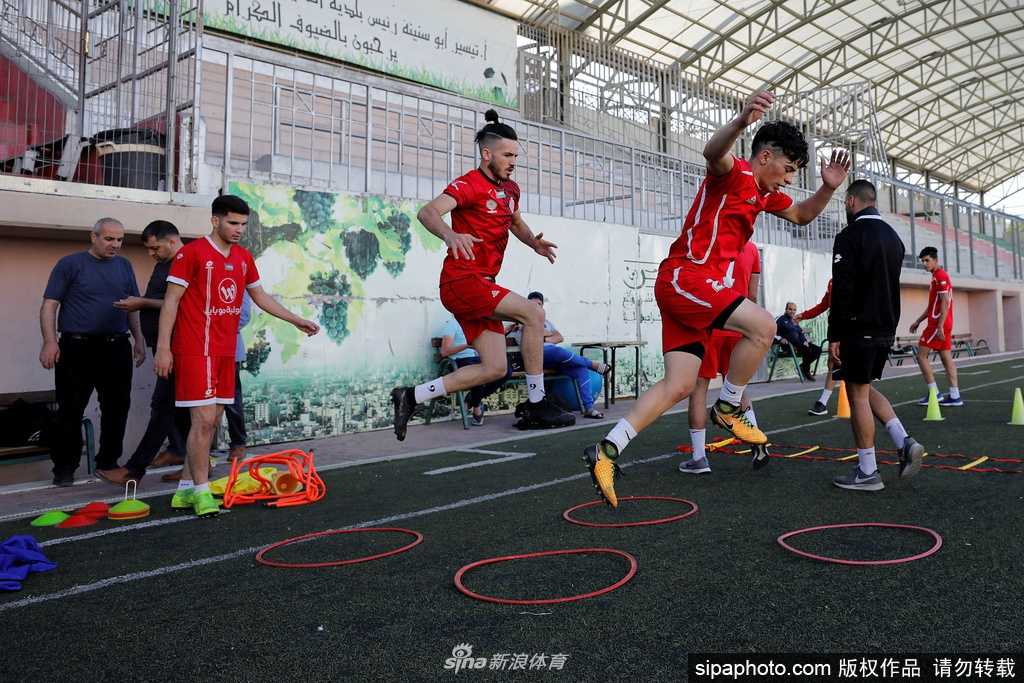 训练结束，几名阿赫利球员肩并肩走向场边，虽然彼此保持着一定的距离，但夕阳将他们的身影拉长交织在一起，预示着球队的凝聚力和对未来的共同期待。