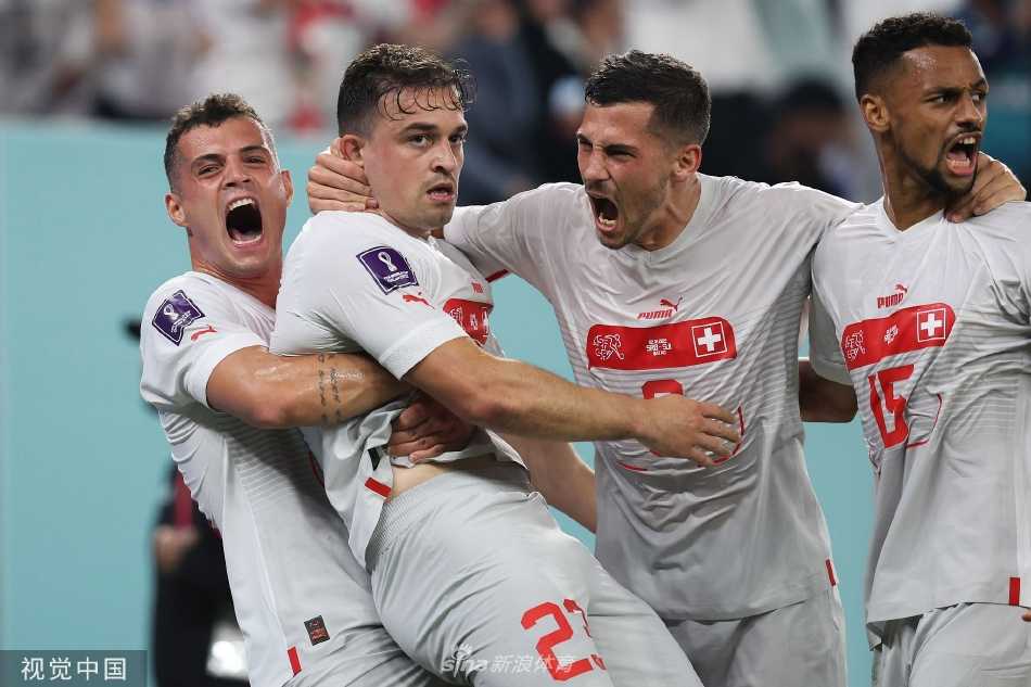 比赛终场哨响，瑞士球员振臂欢呼庆祝晋级，而背景中塞尔维亚球员落寞的身影形成了胜利与失落的鲜明对比。