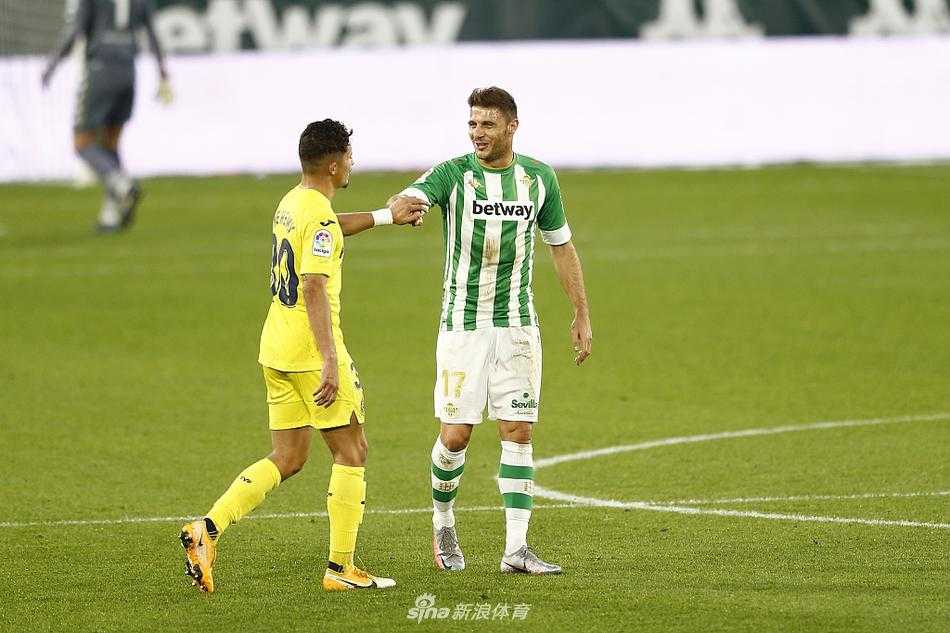 贝蒂斯铁卫巴尔特拉眼神坚毅，在湿滑草皮上飞身铲断比利亚雷亚尔边锋楚克乌泽的突破，溅起的草屑与雨水见证着这场寸土必争的领地守护。