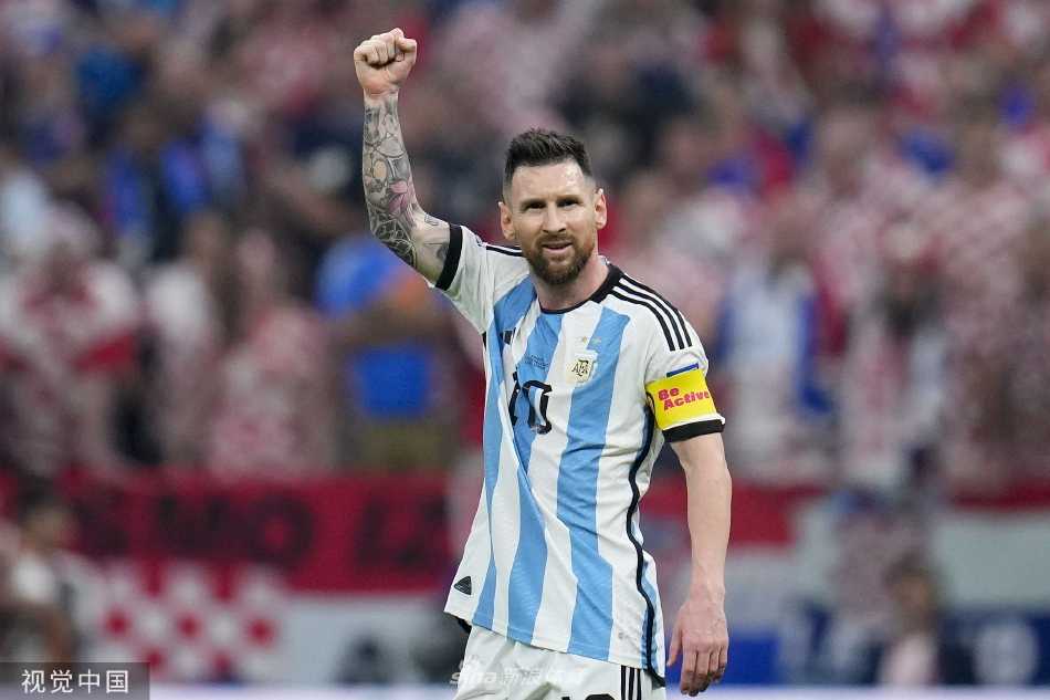 梅西在比赛结束后向看台上的阿根廷球迷挥手致意，眼中闪烁着对决赛的坚定与渴望。