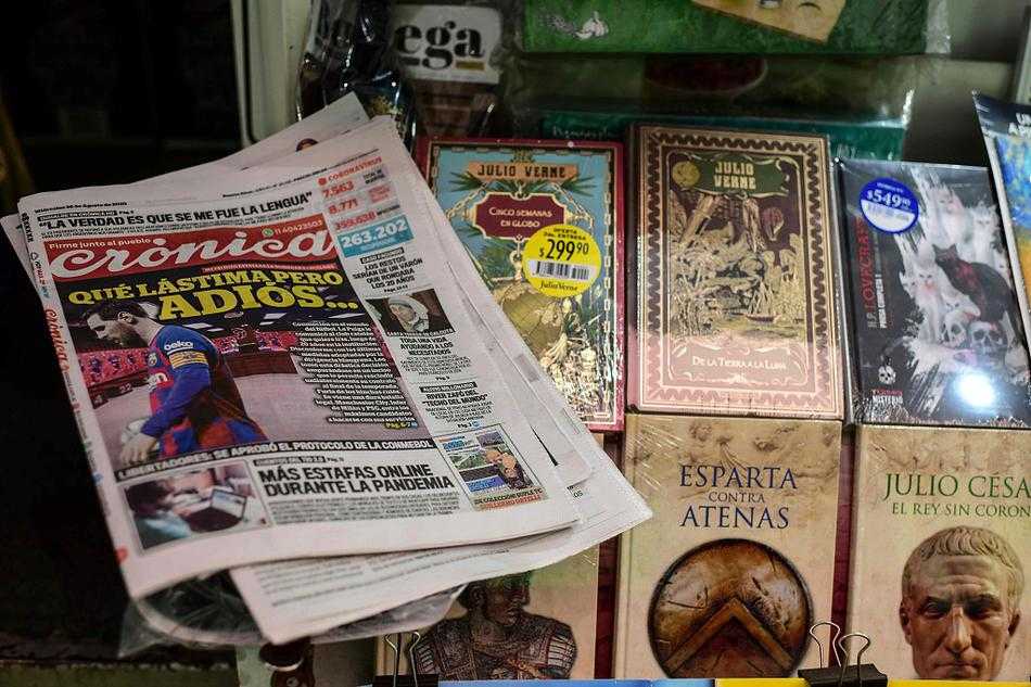 布宜诺斯艾利斯的街头报摊上，叠放着一叠印有梅西头像的报纸，头版标题醒目地宣告着这位球王即将告别诺坎普的消息，晨光洒在报摊上，让每一个路过的行人都不禁驻足凝视这则改写足球版图的新闻。