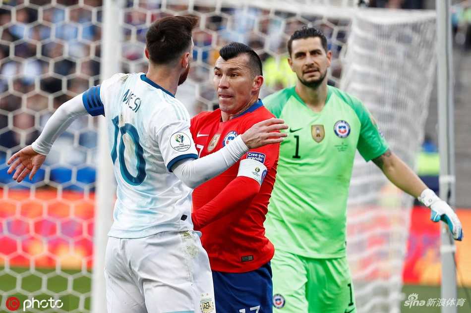 梅西与梅德尔胸脯顶着胸脯怒目而视，火药味十足，梅西眼神中透露出少见的倔强与愤怒，梅德尔则如斗牛士般毫不退让