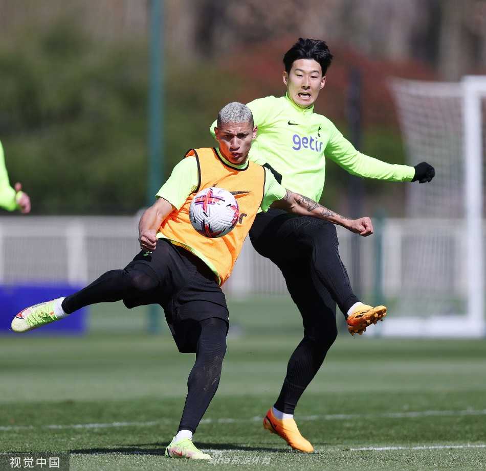 主帅在场边凝神观察训练，手持战术板与助手深入交流