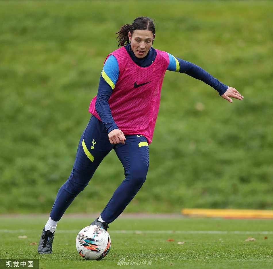 唐佳丽与另一位队友面对面相视而笑，手中各拿着一个足球，气氛轻松愉悦