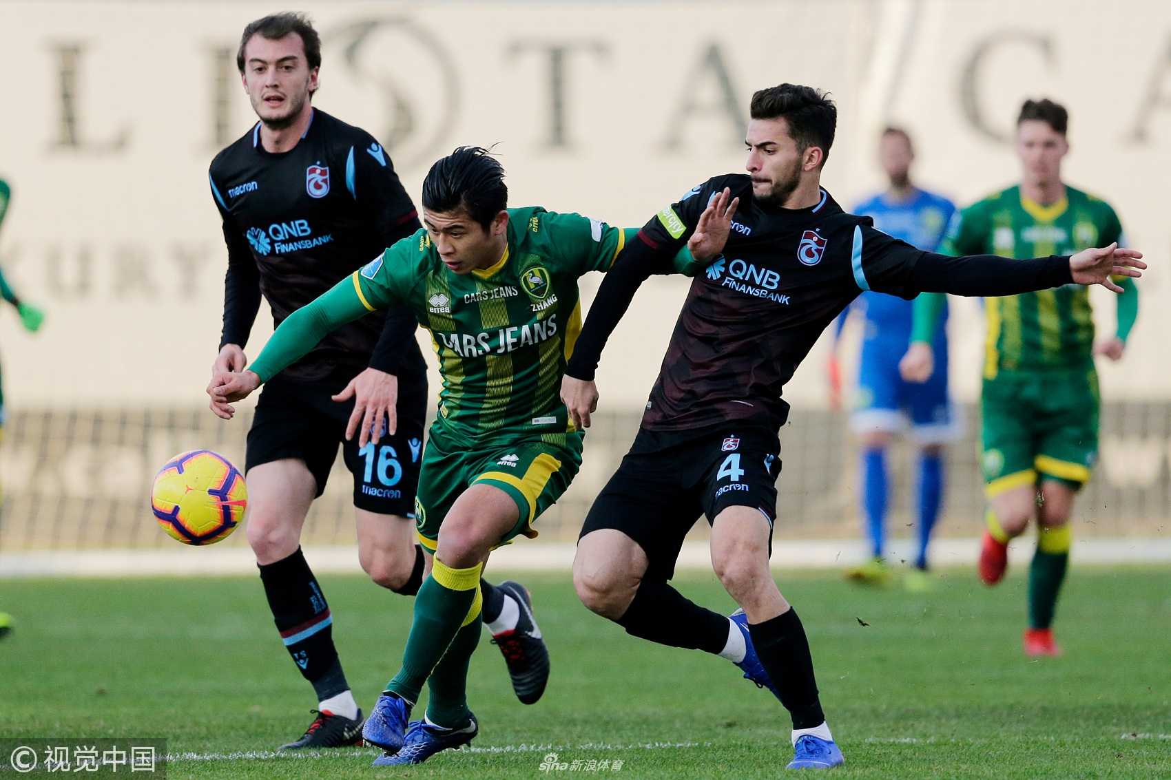 张玉宁背身倚住对方高大的防守球员，稳稳地将球控制在脚下，正准备转身突破