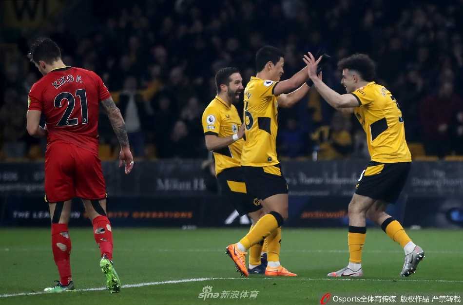 沃特福德门将本·福斯特出击失误后一脸懊悔，狼队球员则在远处庆祝球队的第三个进球。