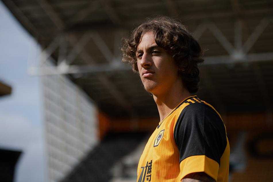 定妆照拍摄间隙，席尔瓦在背景板前整理衣领，举手投足间已初具球星风范，即将开启他的英超冒险。