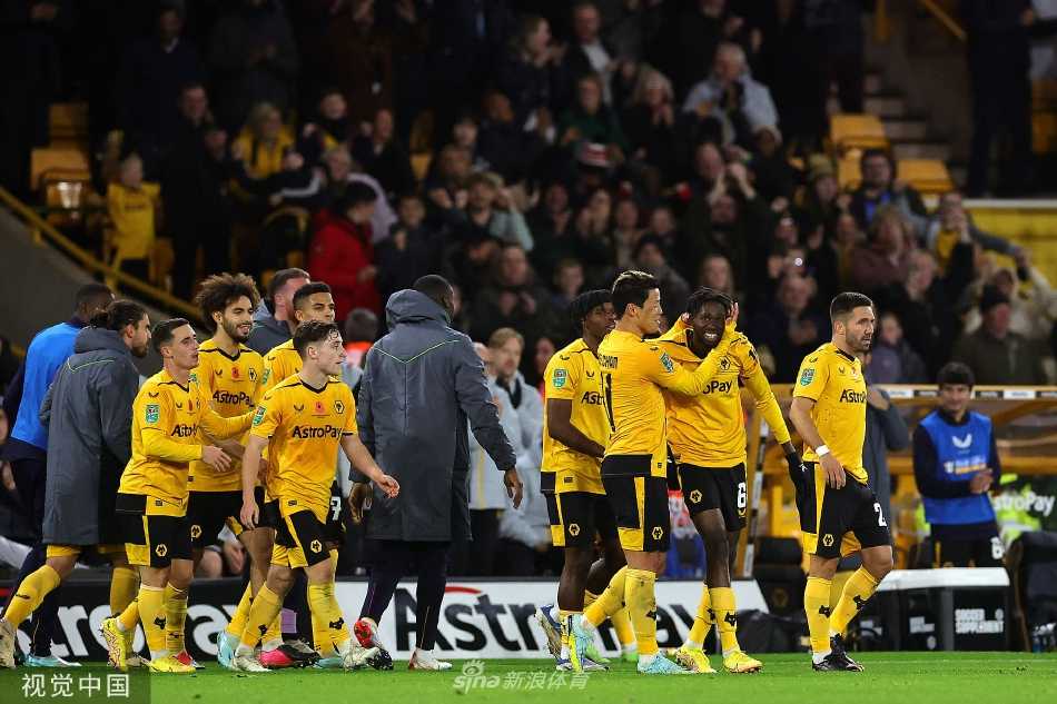 进球功臣布巴卡尔·特劳雷张开双臂，面向看台激情庆祝，身后是蜂拥而至一同分享喜悦的狼队队友。