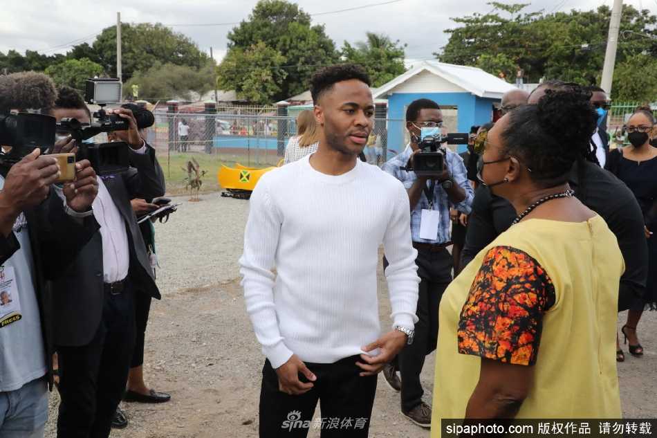 威廉王子与凯瑟琳公爵夫人一同坐进鲜艳的牙买加奥运雪车模型内部，两人脸上洋溢着新奇与愉快的笑容，与雪车队成员交谈。