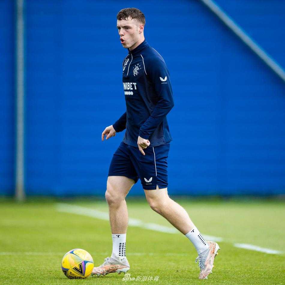 两位身穿蓝色训练服的队友并肩慢跑，他们的影子在绿茵场上被拉得很长，仿佛是在并肩走过这个伟大的赛季，彼此间的信任与情谊无需多言。