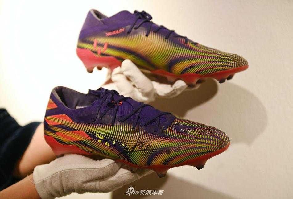 从脚下到殿堂，这双承载着644球纪录的球鞋被置于庄严的展厅中，背景的古典油画与眼前的现代足球装备形成奇妙对话，仿佛一位王者在此加冕，即将奔赴下一个更重要的慈善战场。