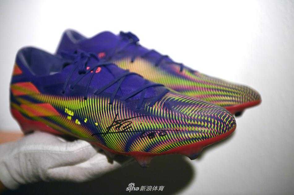 历史的见证与未来的希望，球鞋侧面特写中，阿迪达斯的三道杠标志与鞋底沾染的草屑清晰可见，它们刚刚亲历了644球的诞生，现在即将启程去改变更多年轻生命的轨迹。