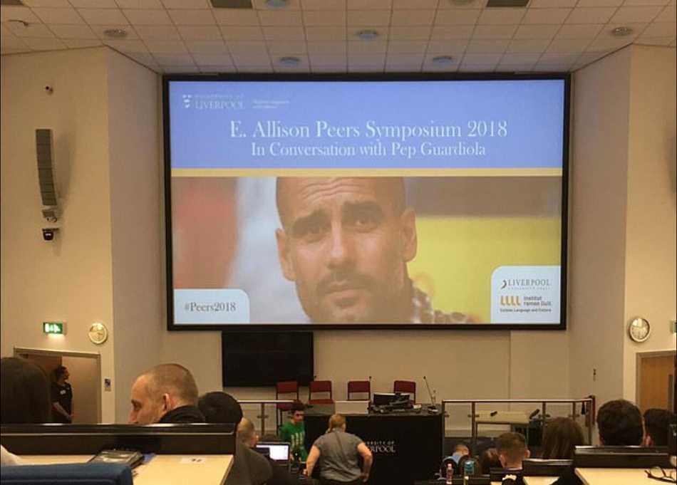 演讲现场的一块战术板上，画着简单的足球阵型图，仿佛让人联想到瓜迪奥拉此刻正在向未来可能成为教练的学子们，拆解他脑海中那些复杂而精妙的攻防套路。