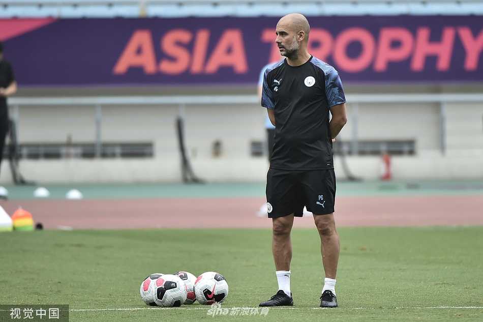 曼城球员们在南京的训练场上进行分组对抗，多人围抢的场景激烈，瓜迪奥拉在场边双手插兜，神情严肃地观察着攻防转换。