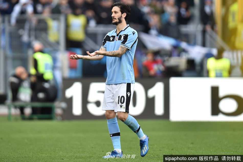 路易斯·阿尔贝托双手抱胸，神情专注地凝视前方，身后的拉齐奥队徽在阳光下熠熠生辉，预示着他将成为未来球队的领航者