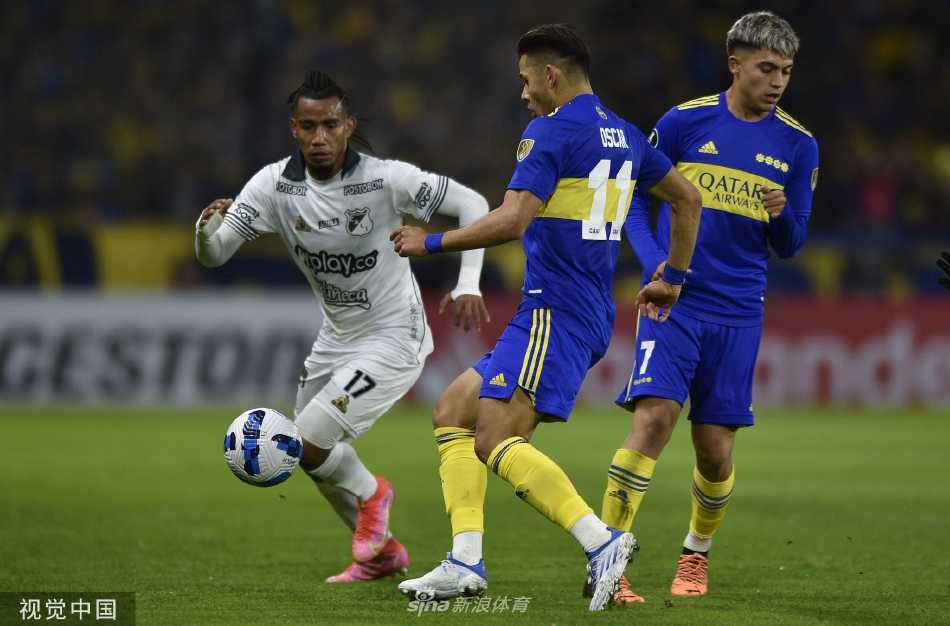 看台上一位小球迷身穿偶像球衣，紧握栏杆，眼神专注地凝望着场内激烈的拼抢，充满对胜利的渴望。