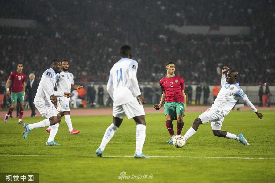 摩洛哥球员破门得分后张开双臂滑跪庆祝，身后是欢呼的队友和沸腾的红色看台，激情与喜悦在此刻完全释放。