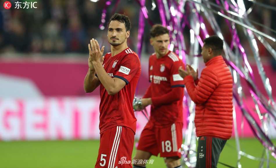 托马斯·穆勒与队友聚在一起，开怀大笑，共同庆祝来之不易的胜利，他们的球衣都已被汗水浸透。