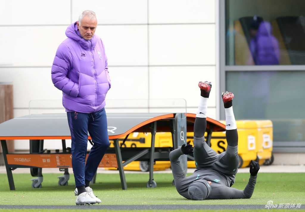 穆里尼奥在训练间隙与恩东贝莱交流，手势丰富地进行讲解，展现出教练的专注。