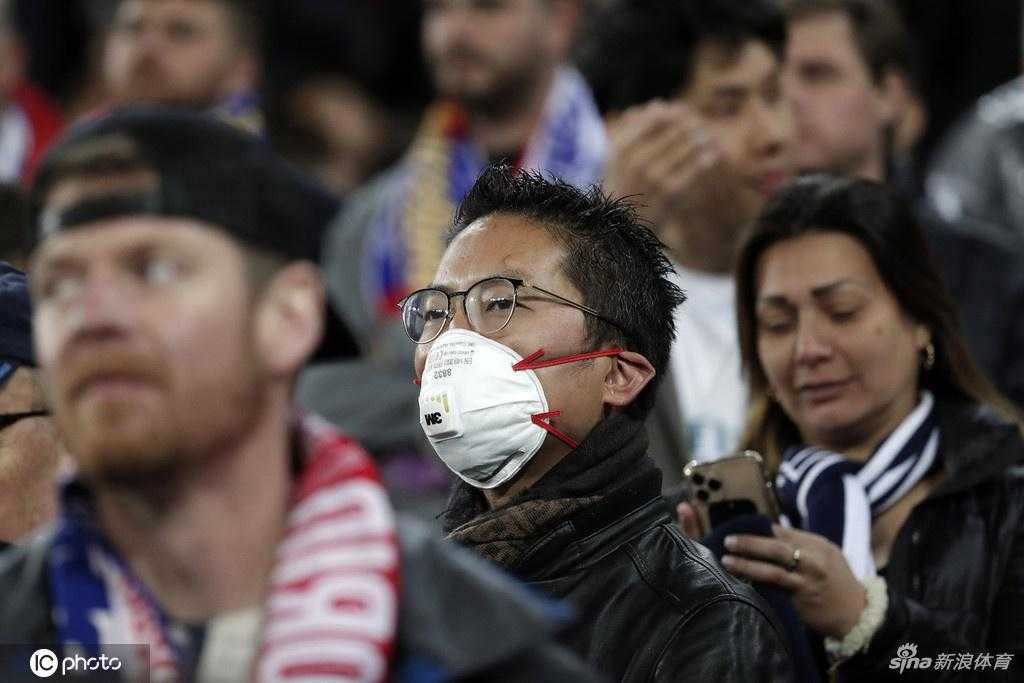 远景看台上，在密密麻麻的观众人群中，几个戴着口罩的亚裔面孔显得格外醒目，他们如同散落在白色海洋中的彩色坐标，默默见证着历史。