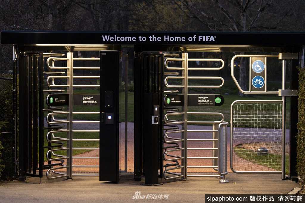 训练场上，一名球员正弯腰捡起滚落在脚边的足球，他的身影在空旷的球场中显得专注而执着，仿佛在积蓄力量等待哨声再次响起。