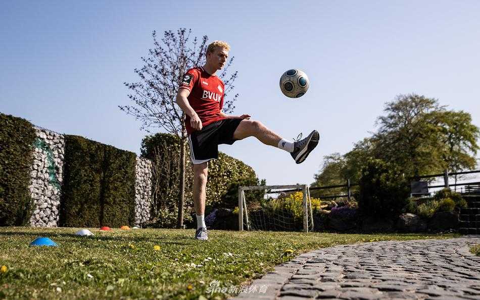 球员将沉重的红酒木箱当作健身踏板，进行高抬腿练习，汗水浸湿了他的背心，显示出居家训练的认真与投入。