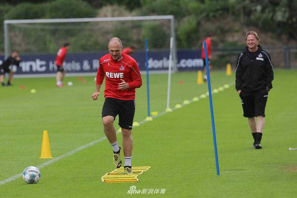 在空旷的莱茵能源体育场内，科隆球员独自进行着绕杆训练，阳光斜射在看台上，巨大的阴影与球员专注的身影形成鲜明对比，寂静的球场内仿佛只剩足球与草皮的摩擦声。