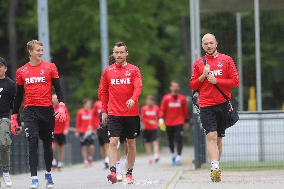 夕阳的余晖洒在训练场上，两名科隆球员保持着数米的间距进行传接球配合，他们的影子被拉得很长，仿佛在无声地诉说着特殊时期的“距离美学”与对比赛共同的渴望。