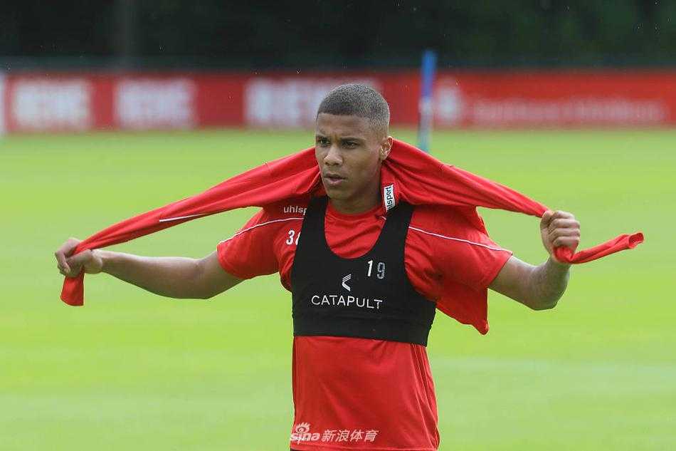 训练场上，一名科隆球员正全神贯注地面对来球，准备凌空抽射，他身后的看台上悬挂着巨大的俱乐部旗帜，虽然此刻无人喝彩，但他心中装的是整座城市的期盼。