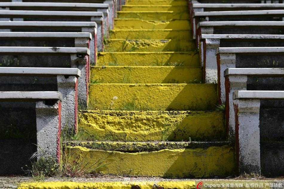 从球门后方的视角看去，整个球场尽收眼底，却不见一名球员和观众。主队替补席的座椅整齐地摆放着，草皮在养护下依然鲜绿，但这片为战斗而生的舞台，此刻却只能孤独地等待，仿佛时间在这里凝固。