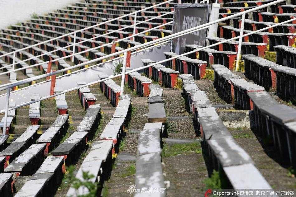 从球场看台高层俯瞰，空无一人的草皮修剪得异常平整，对面看台“Royal Antwerp”的字样清晰可见，但这份精致无人喝彩，只有电子广告牌静静地闪烁着，见证着这片绿茵场前所未有的孤寂。