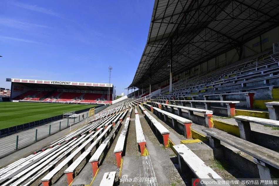 球场边的球员通道入口处，铁网门紧闭，门上悬挂的旗帜无力地低垂。这里曾是球员们奔赴战场的起点，如今却如同一道隔绝喧嚣与生机的屏障，将足球的激情牢牢封锁在门外。