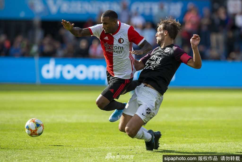 一只足球静静地停放在空无一人的球员通道入口处，光线从球场内照射进来，仿佛在召唤着球员们重新登场，但此刻它只能孤独地等待着。