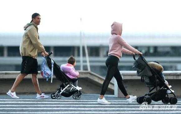 走在队伍最前面的迷你罗，身穿蓝色外套，好奇地回头张望，似乎对路边的事物充满了兴趣，父亲C罗则紧跟其后，目光始终没有离开过前方的孩子们，尽显父爱如山。