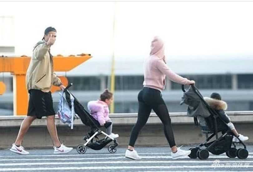 C罗身穿白色T恤，戴着墨镜，满脸笑容地与身旁的粉丝挥手互动，完全没有巨星的架子，身后的乔治娜也面带微笑，整个氛围轻松而愉快，仿佛刚才的风波从未发生过。