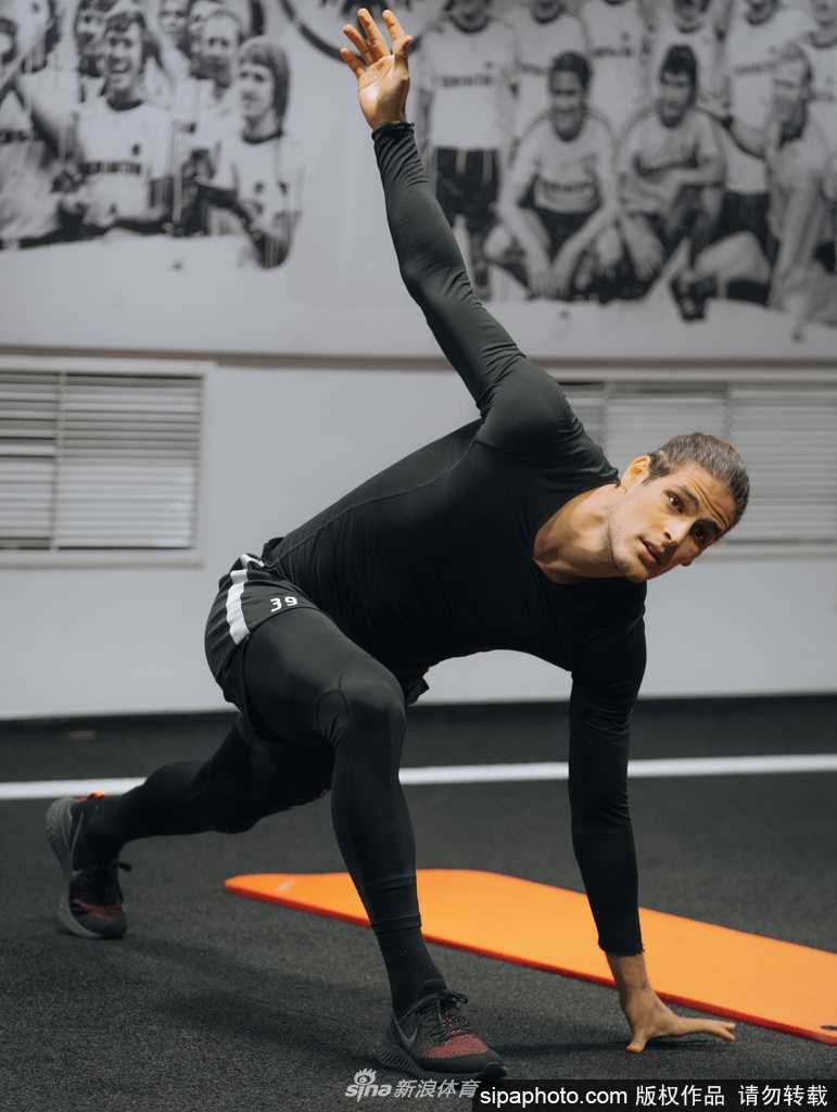 一名球员正在进行个人加练，反复练习着传中球的落点控制。他的每一次触球都力求完美，因为在这片寂静的训练场背后，是无数球迷等待足球回归的炽热目光。