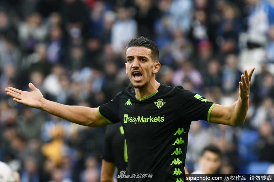 空场下的坚守：空无一人的贝尼托·比利亚马林球场看台，座椅上覆盖着巨大的队旗，仿佛那些缺席的球迷依然在场。阳光洒在空旷的绿茵上，静静等待着往日的激情与呐喊重新回归。