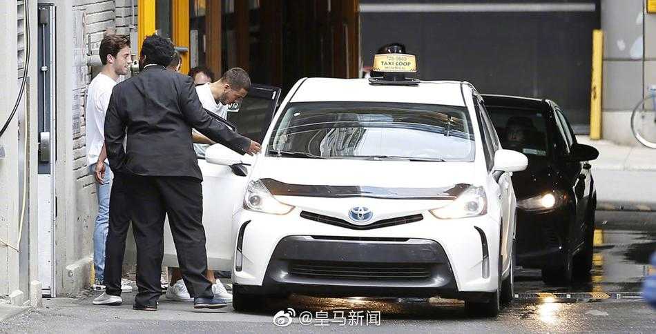 久保建英与卢宁在马德里街头并肩而行，两人都穿着休闲装，久保面带微笑侧头与高大的卢宁交谈，气氛轻松愉快。