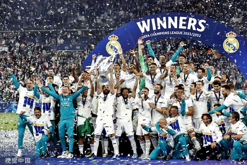 利物浦主帅尤尔根·克洛普在颁奖仪式上神情落寞，背景中是庆祝的皇马球员，胜负之间的残酷与体育精神并存。