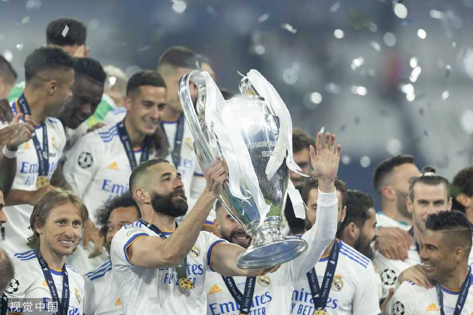 皇马球员卢卡·莫德里奇与队友相拥庆祝，眼中闪烁着胜利的泪光与无悔的坚毅，老将的梦想在此刻圆满。