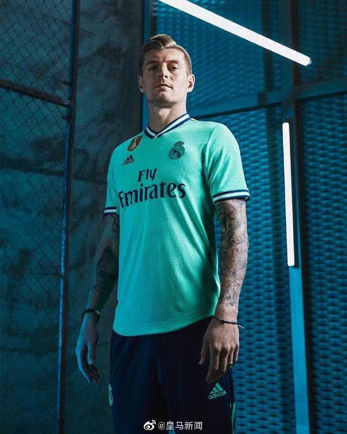 近距离特写皇马新球衣的领口与金色队徽，精致的刺绣和金色镶边彰显细节，但其领口样式与阿森纳球衣如出一辙。