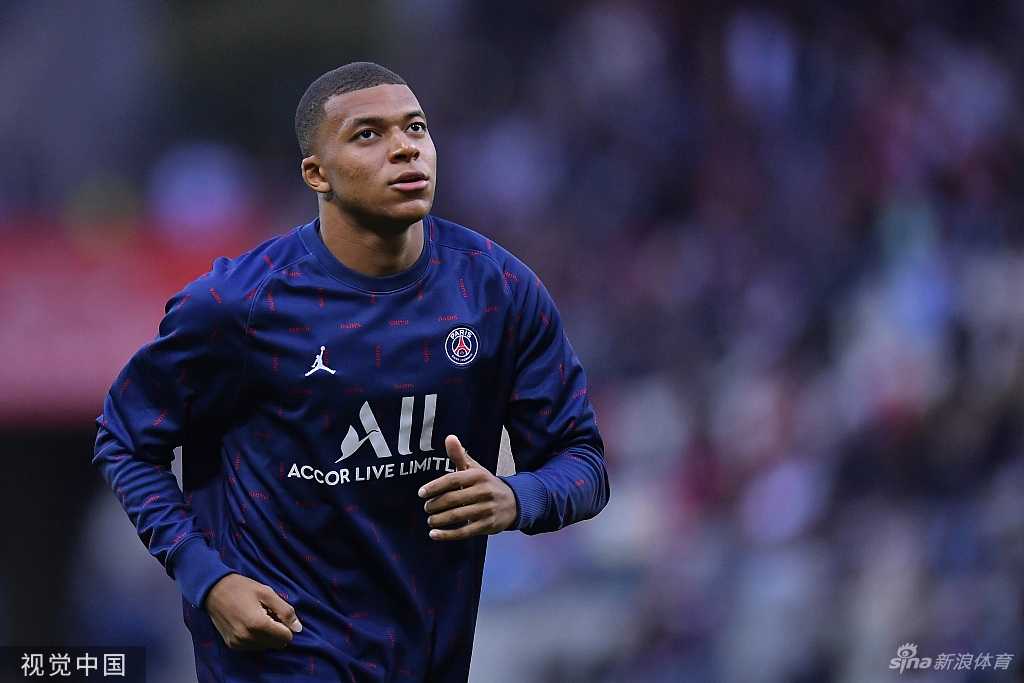 姆巴佩在比赛中带球突破，他身后是试图拉拽却只能望其项背的防守球员，白色的球衣在绿茵场上划出一道耀眼的闪电