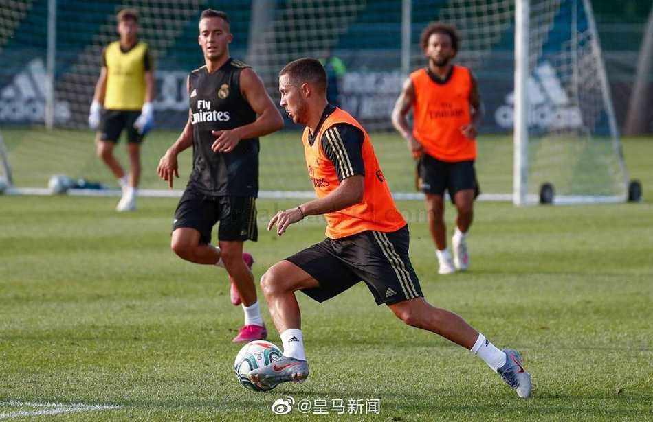 阿扎尔在皇马首训中轻巧地卸下高空球，他的眼神专注而自信，仿佛脚下的白色战靴已与绿茵融为一体，巨星气质在这一刻自然流露。