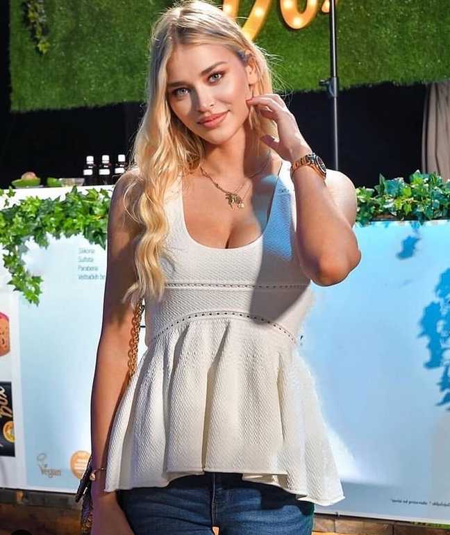 索菲亚在午后阳光下回眸一笑，随性的穿搭难掩其超模气场，金色的阳光勾勒出她精致的面部轮廓，显得格外迷人。