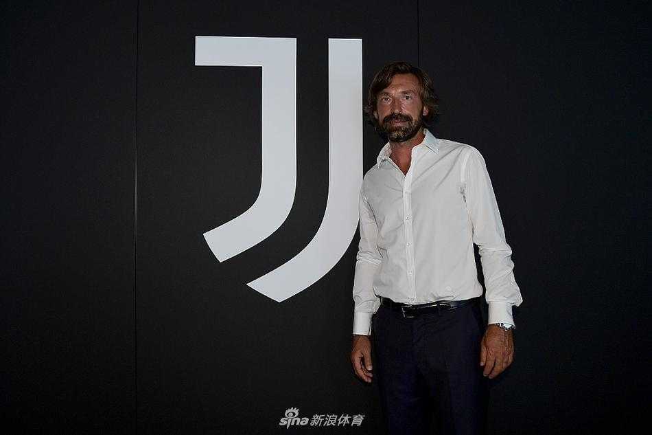 特写镜头下，皮尔洛双手交叉放在桌上，面前摆放着话筒和带有尤文图斯logo的水瓶。他的神情专注而投入，正在阐述对球队未来的规划，标志性的胡须和深邃的眼神，依然保持着球员时代那般优雅，只是多了几分作为决策者的严肃。