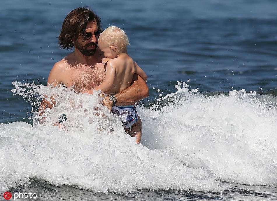 海浪拍打着岸边，皮尔洛专注地守护着正在玩耍的儿子，无论他在球场上多么叱咤风云，此刻只是一个满眼都是孩子的普通父亲。