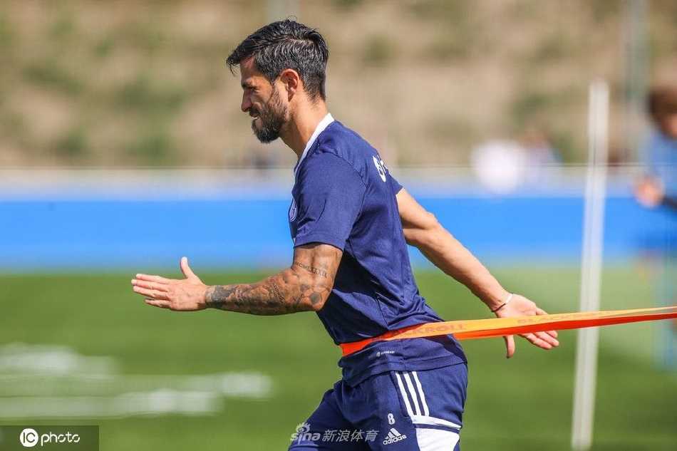 球员专注地进行带球绕杆训练，步伐敏捷，眼神紧盯着脚下的皮球，展现着对基础技术一丝不苟的打磨。