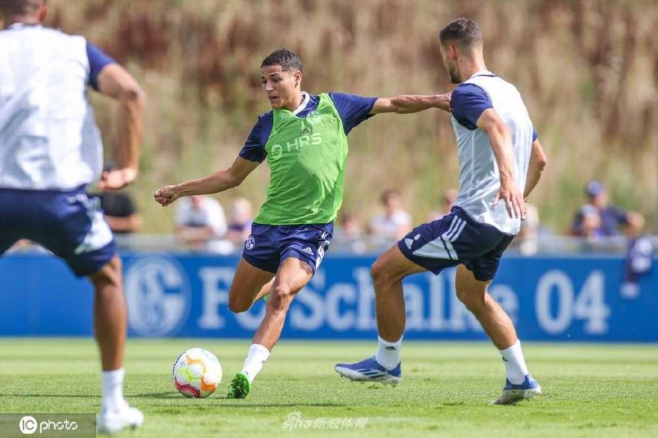 训练间隙，球员们坐在草地上轻松交流，笑容灿烂，短暂休憩中弥漫着战友间的默契与轻松氛围。