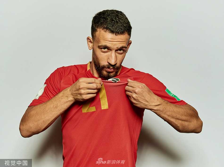 中场核心在慢跑中回眸凝视，眼神中透露着沙漠狼一般的警觉与深邃，仿佛在观察着赛场上的每一个猎杀机会