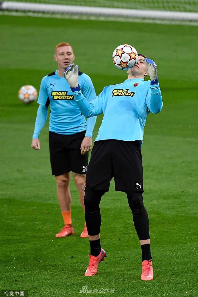 一名矿工球员正在独自进行拉伸训练，他的身影在偌大的球场中显得有些孤独，却无比坚韧，仿佛象征着这支流浪的球队虽然远离家乡，却始终扎根在足球的土壤里。